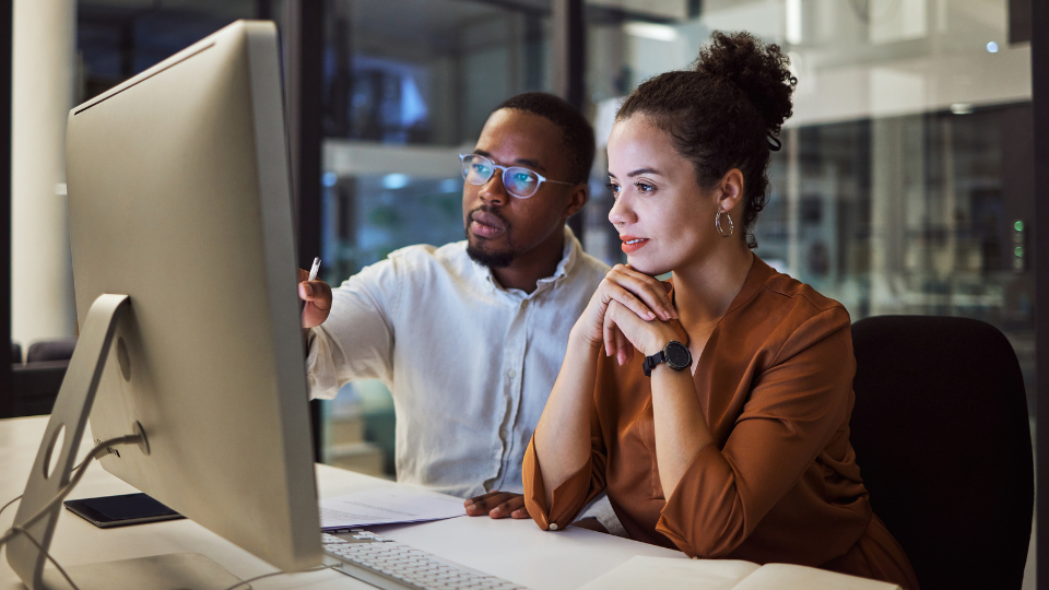 Two young professionals working at a computer